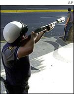 Riot policeman aims tear-gas round in Caracas