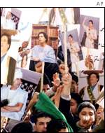 Demonstrators holding placards of Col Gaddafi